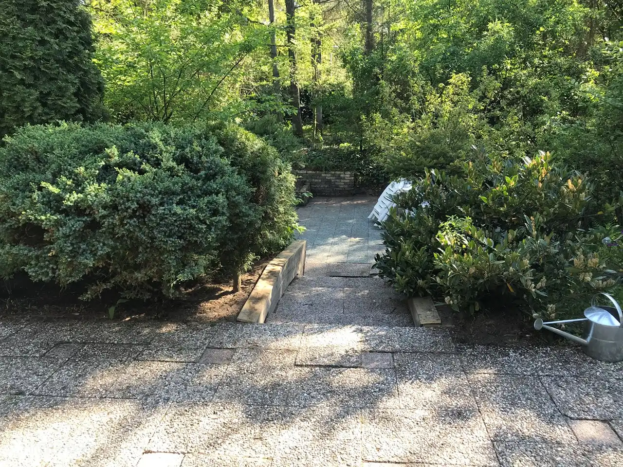 Durch Garten zum großen Sitzbereich mit Sitzgelegenheiten. In der Garage stehen verschiedene Stühle und Sonnenschirme zur Verfügung, um sie irgendwo im weitläufigen Garten zu platzieren.