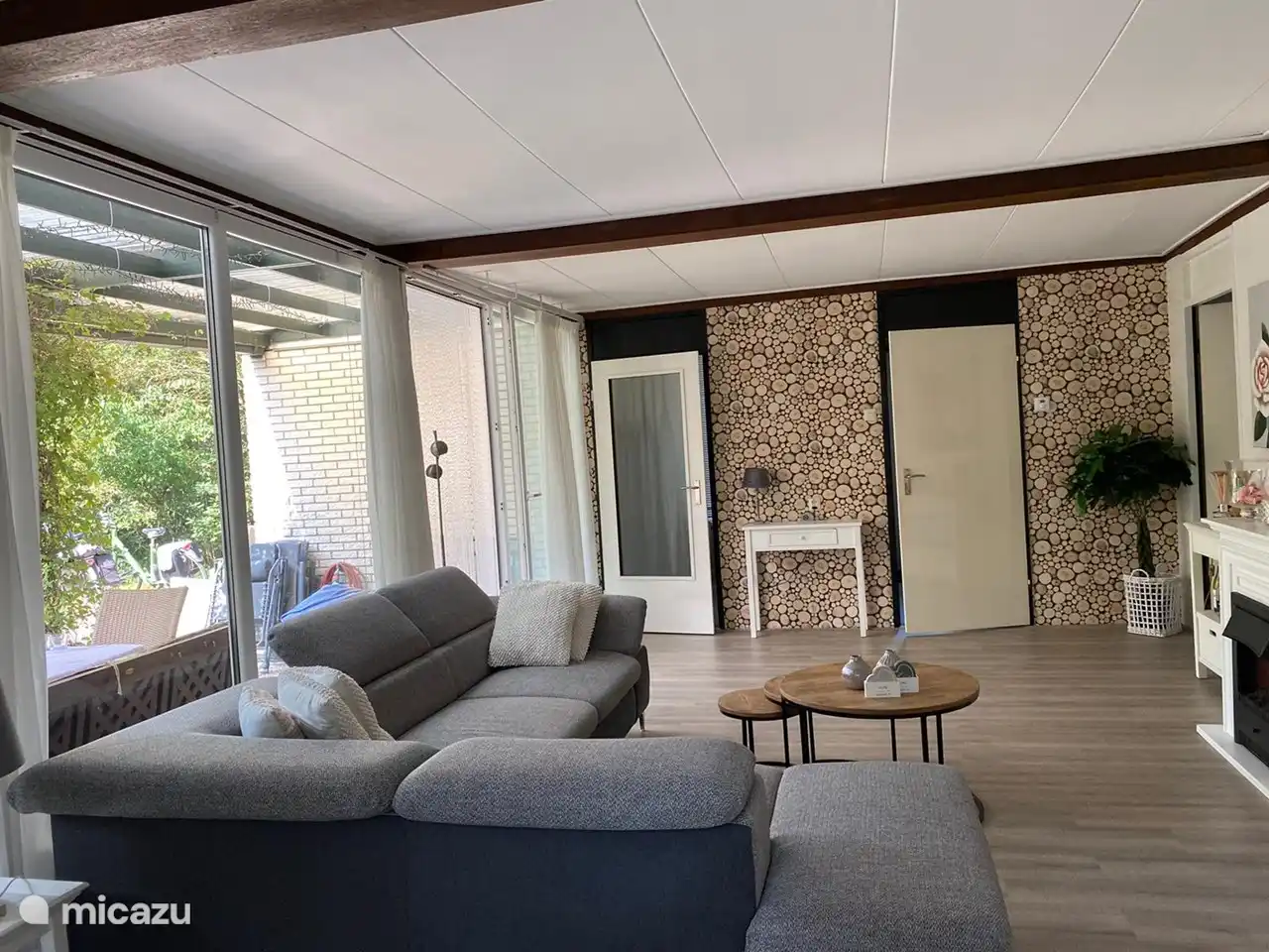 Wohnzimmer mit Schiebetüren und Blick auf Terrasse und Garten