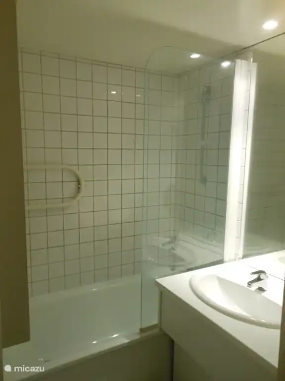 Zwei identische Badezimmer mit Badewanne-Dusche und Waschbecken