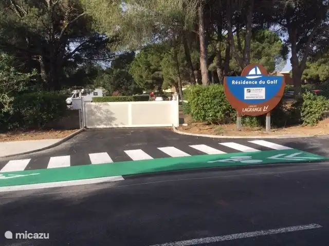 Das Eingangstor zum Parkplatz der Residenz mit komplett renoviertem Rad- und Wanderweg zum Strand, von der Straße getrennt.