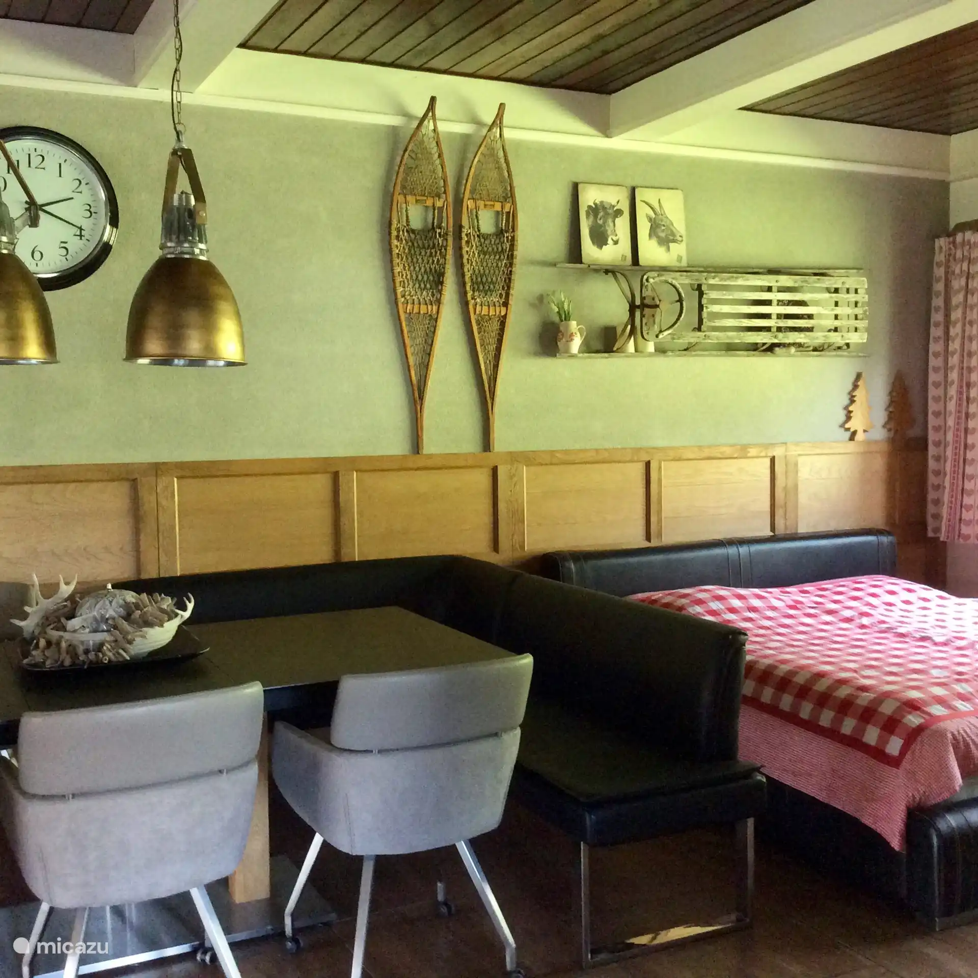 El amplio comedor con sofá de esquina y detrás de él la cama doble en la parte trasera de la sala de estar.