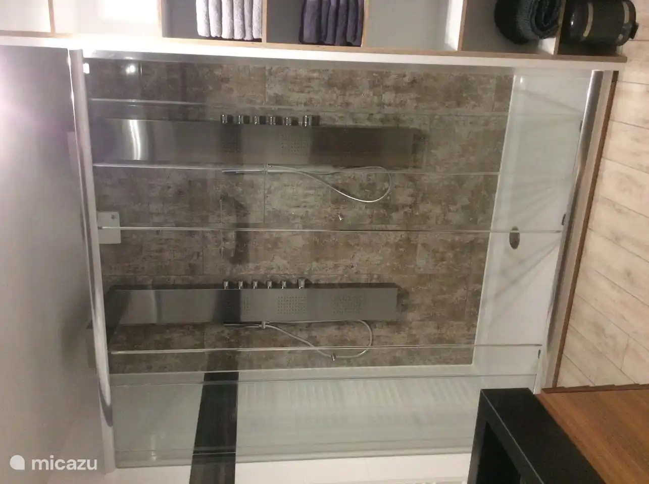 Ducha doble con jets y ducha fija y teleducha con entrada baja.