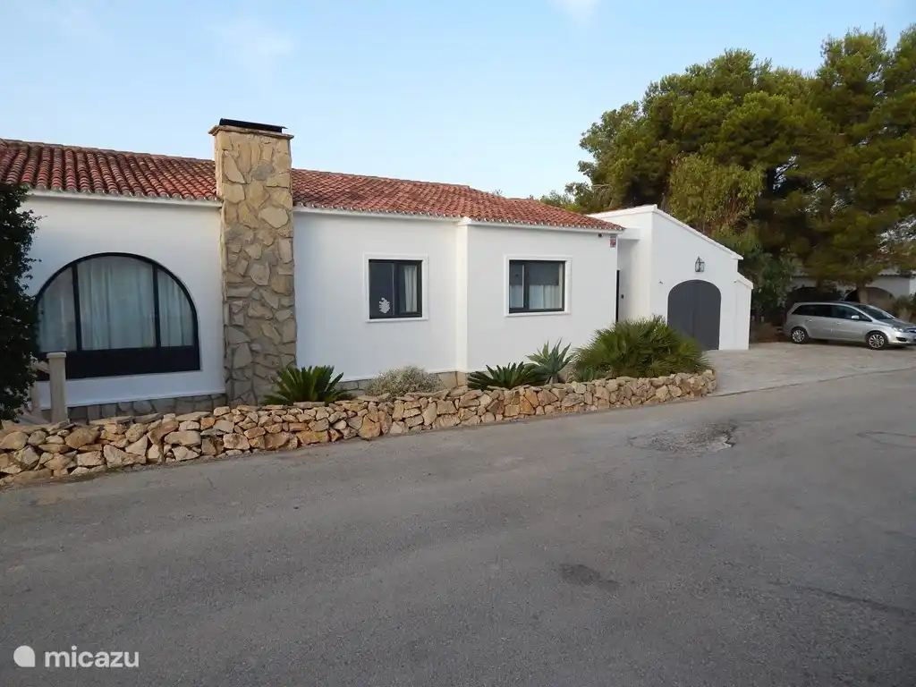 Vorderansicht mit einem großzügigen Stellplatz auf dem Grundstück rechts neben der Garage.