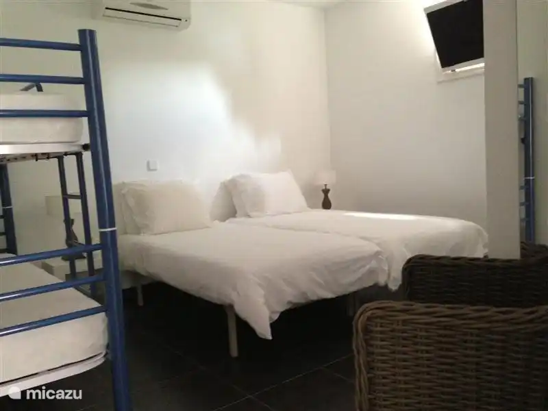 Schlafzimmerwohnung mit Doppelbett und Etagenbett.