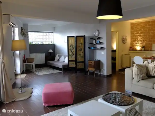 Casa Bedda Acitrezza huren in Italië, Sicilië, Acitrezza - appartement De ruime, lichte, elegante woonkamer van 55M2 met airco, een slaapbank, een zithoek en rechts de open keuken