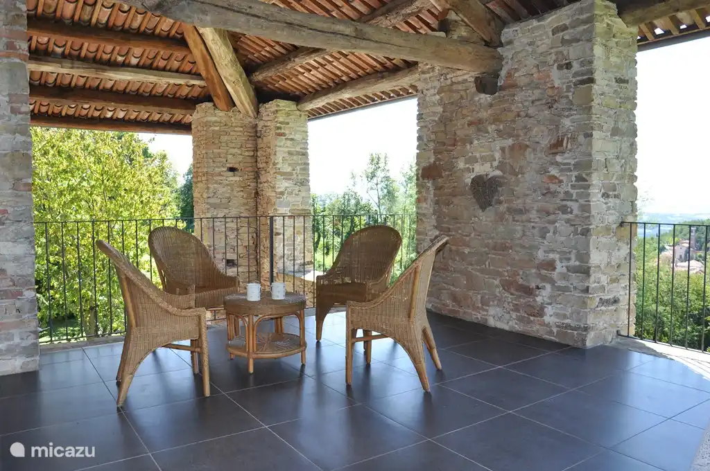 The large upstairs balcony with seating and large dining table.