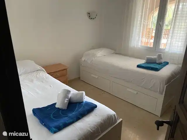 Schlafzimmer zwei mit zwei Einzelbetten mit Schublade darunter und Klimaanlage