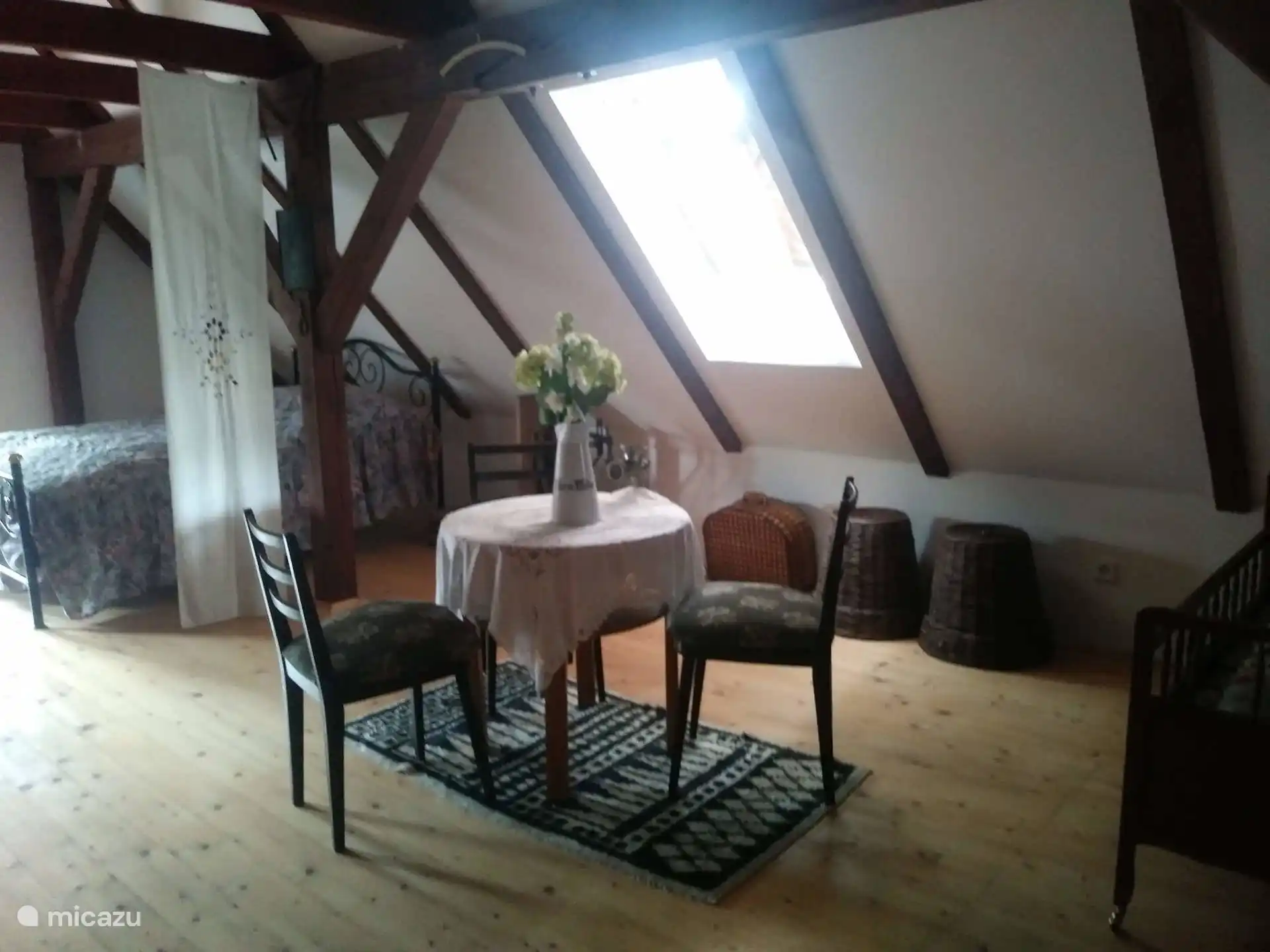 Segundo altillo para dormir con 4 camas dobles, una zona de estar y una cuna para bebés.