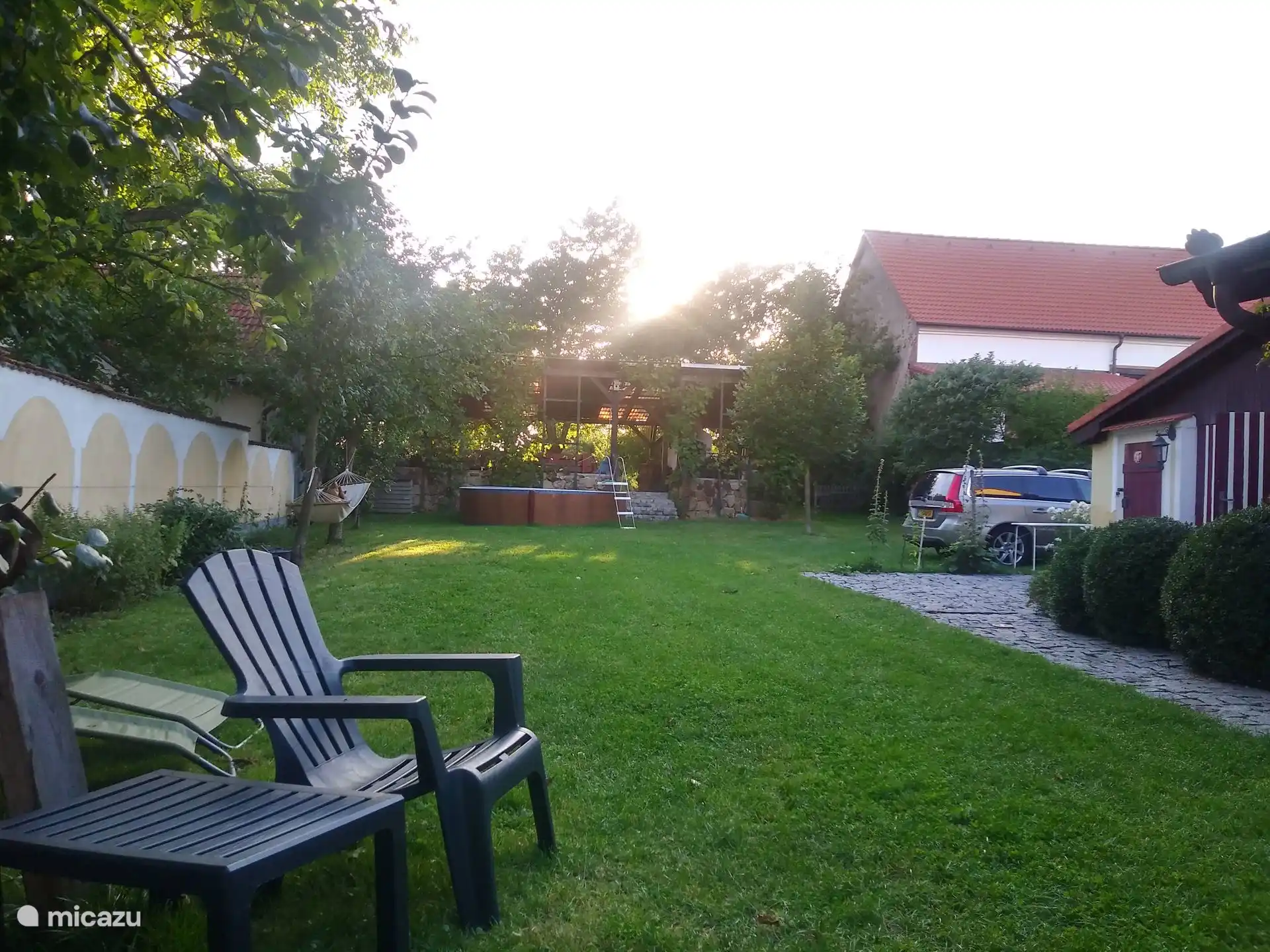 Parte trasera del jardín del patio a principios de primavera. Aquí también se aplica privacidad total. Junto al granero hay una plaza de aparcamiento para dos coches de pasajeros.