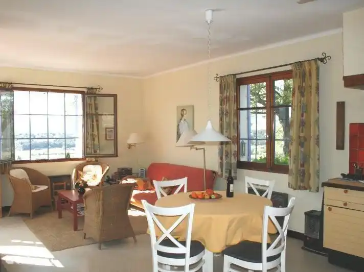 Es ist ein geräumiges und helles Wohnzimmer mit zwei großen Terrassentüren auf die Terrasse und zwei großen Fenstern.