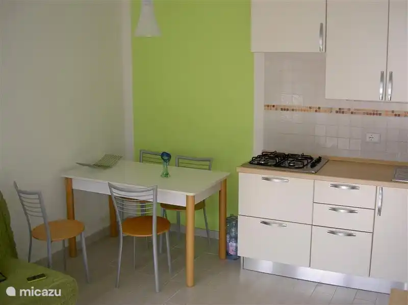 Offene Küche mit Esstisch und 4 Stühle.