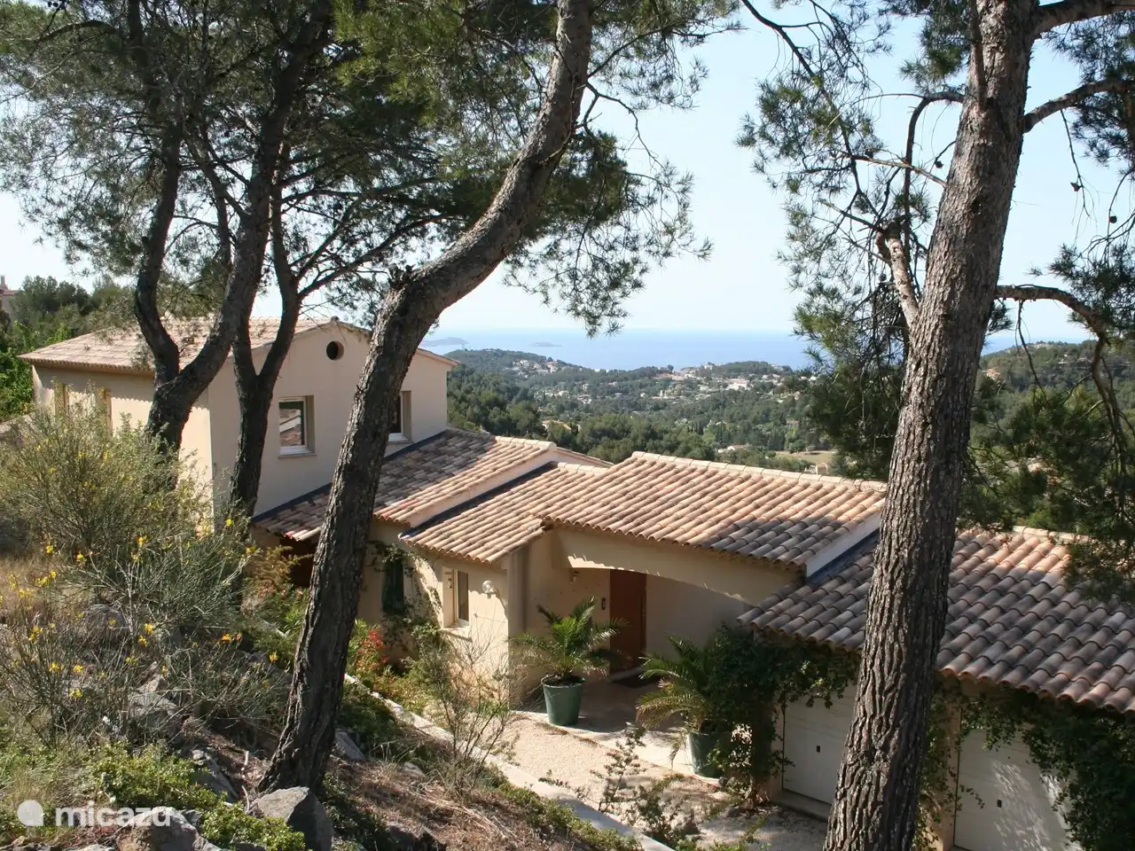 Vanaf het toegangsweggetje (een chemin privé) uitkijkend over de villa, met de zee op de achtergrond.