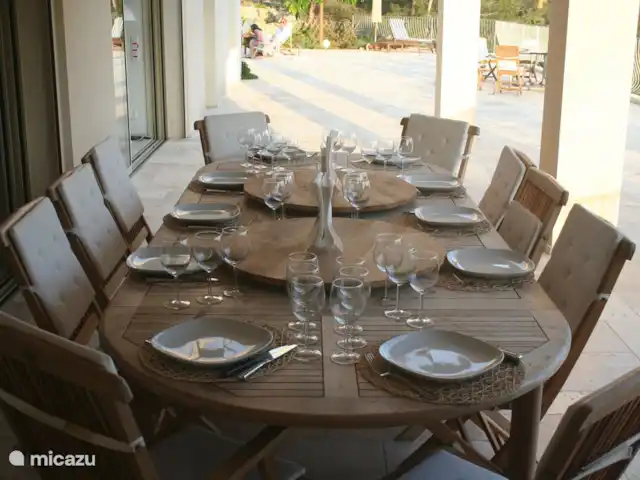 Spacieuse, très spacieuse villa Lou Paradou | France, Côte d'Azur, Bandol - villa Sur la terrasse couverte - à côté de la cuisine et à côté de la porte coulissante 2 sur 4 mètres - se trouve la table d'extérieur fixe en teck. Ceci est adapté pour 12 personnes (couvert ici pour 10). Sur la table deux platines faites maison,