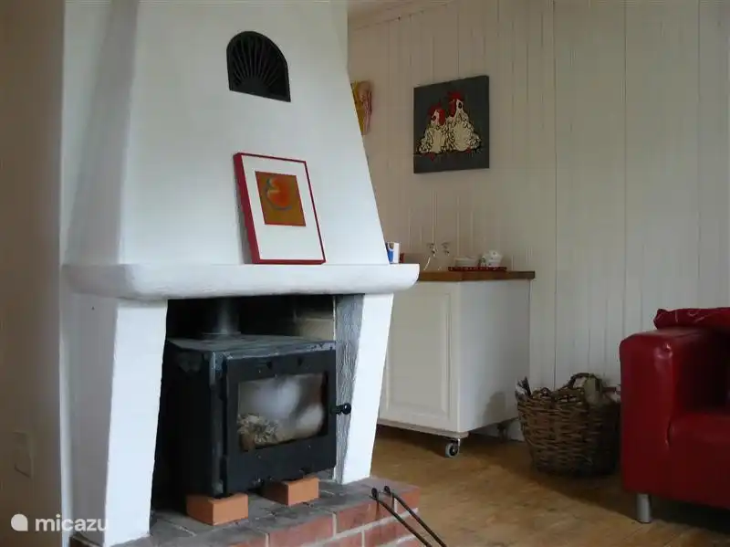 gemütliches Wohnzimmer mit Leder klippanbank Rottöne, zwei schwarzen Ledersesseln und einem gemütlichen POÄNG houtkachtel.