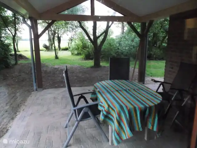bungalow huren in Nederland, Gelderland, Hummelo – Hessenhuisje Op het nieuwe overdekte terras kunt u gezellig buiten eten met uitzicht over de tuin met de goudreinet fruitboom en het weiland met de koeien en de knotwilgen