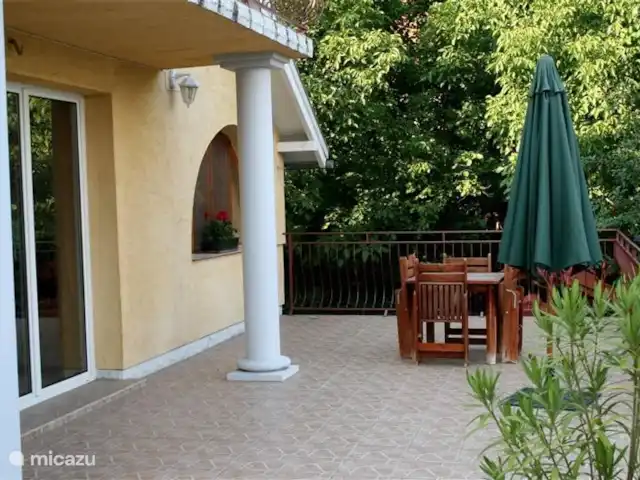 Location de Vacances Hongrie, Lac Velence, Sukoró, bungalow - Maison solaire avec piscine Grande terrasse derrière la maison avec salon de jardin et parasol.