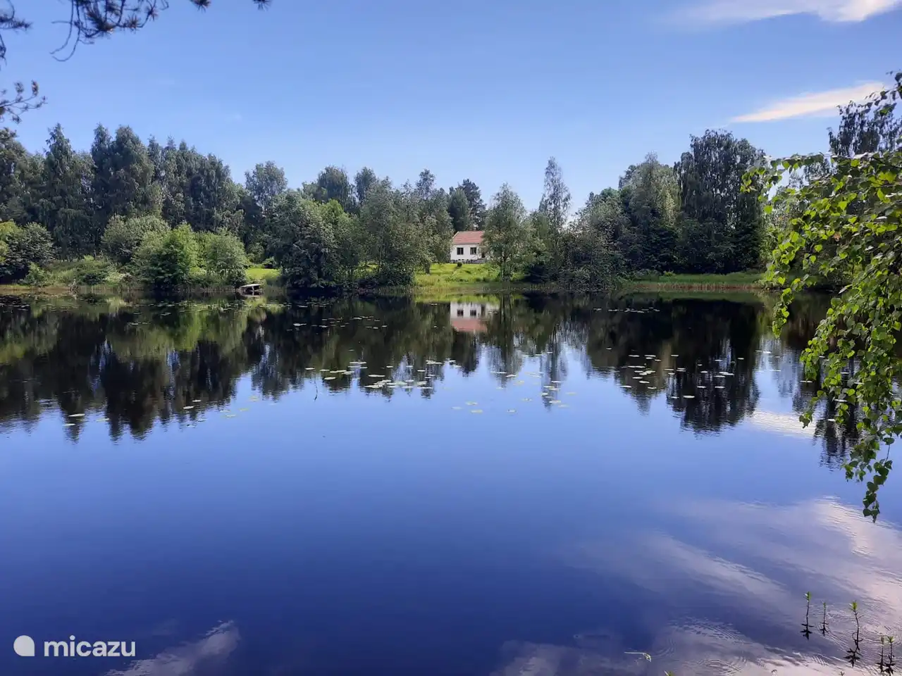 Großes Haus mit schönem Garten an einem See.