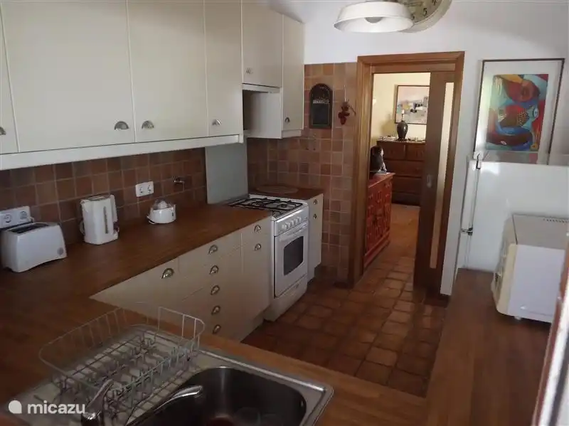 Küche mit Mikrowelle, Backofen, Herd und Kühlschrank.