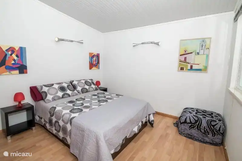 Schlafzimmer mit Doppelbett. Das zweite Badezimmer befindet sich im Flur neben dem Schlafzimmer und hat eine Toilette, Waschbecken und Dusche.