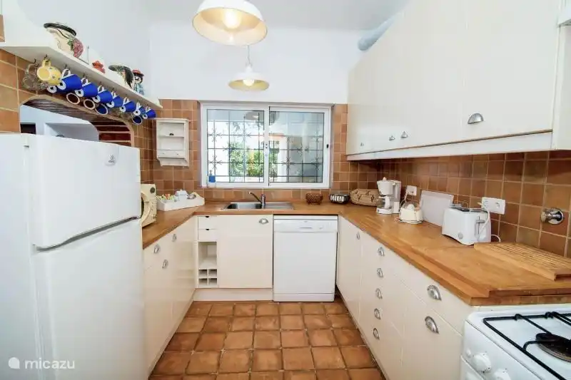 Küche mit Mikrowelle, Backofen, Herd und Kühlschrank.