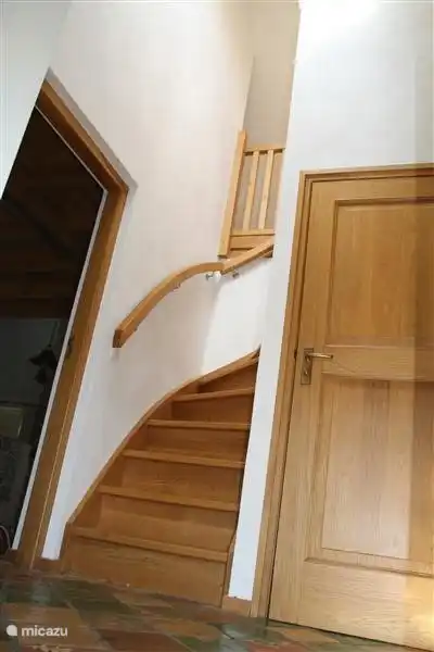 Het vakantiehuis heeft veel eiken elementen wat het een warm geheel geeft. In de hal vindt u naast een deur naar de woonkamer tevens de badkamer en wc en de trap naar boven waar de twee slaapkamers zich bevinden. 
