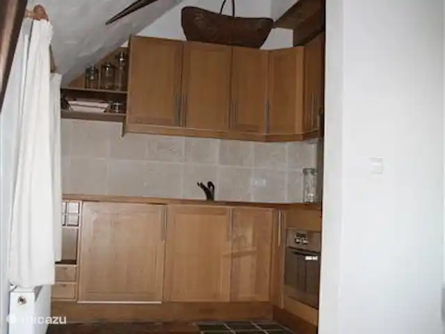 Dwarsgracht 39 en Países Bajos, Overijssel, Giethoorn - casa de campo La cocina tiene forma de L y está equipada con elementos de madera (parcialmente escondida detrás de la pared). La cocina está totalmente equipada y completa con menaje donde poder preparar deliciosos platos. ¿No tienes ganas de cocinar? Giethoon tiene varios restaurantes y descanso. la jaula de las nutrias está enfrente