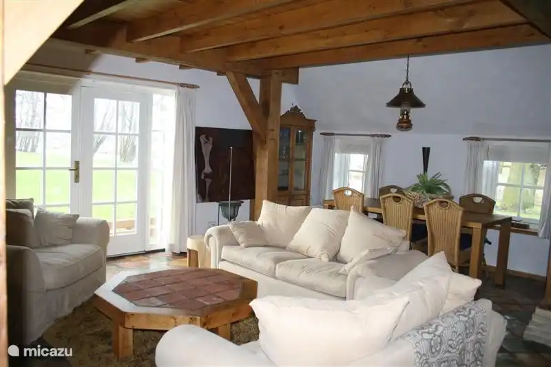 De landelijk ingerichte woonkamer met grote zithoek rondom de (electrische) openhaard en uitkijkend op de tuin met terras is genieten!  