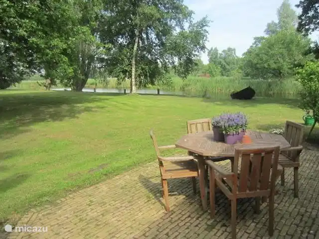 Dwarsgracht 39 en Países Bajos, Overijssel, Giethoorn - casa de campo Vista desde la terraza sobre el jardín, los barcos que pasan y el parque nacional