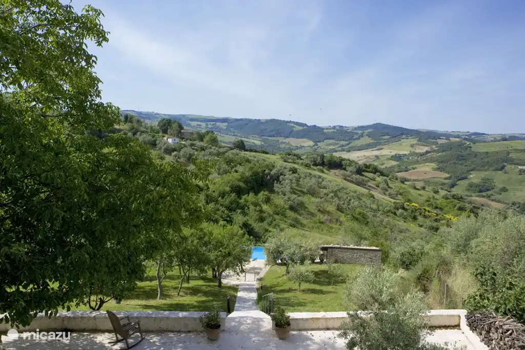 Von der großzügigen oberen Terrasse ist eine Treppe in den Pool