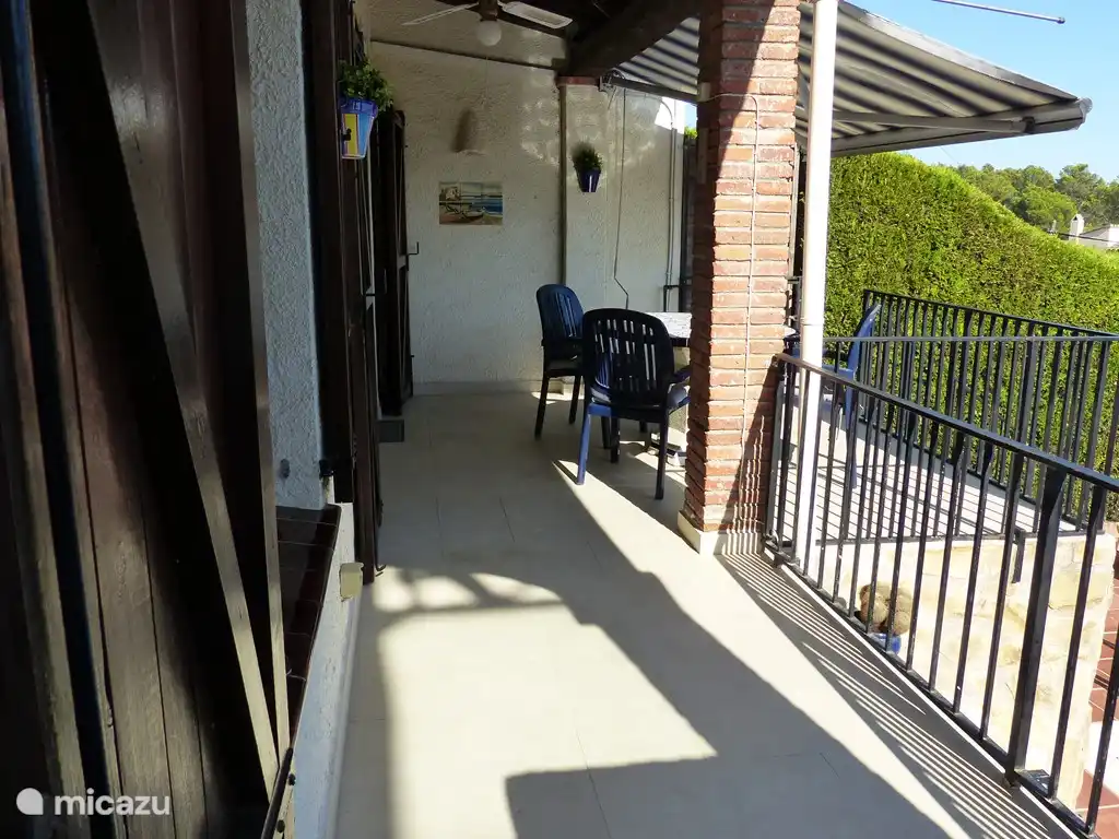 Überdachte Terrasse mit Gartenmöbeln und Sonnenschirmen, direkt neben dem Pool