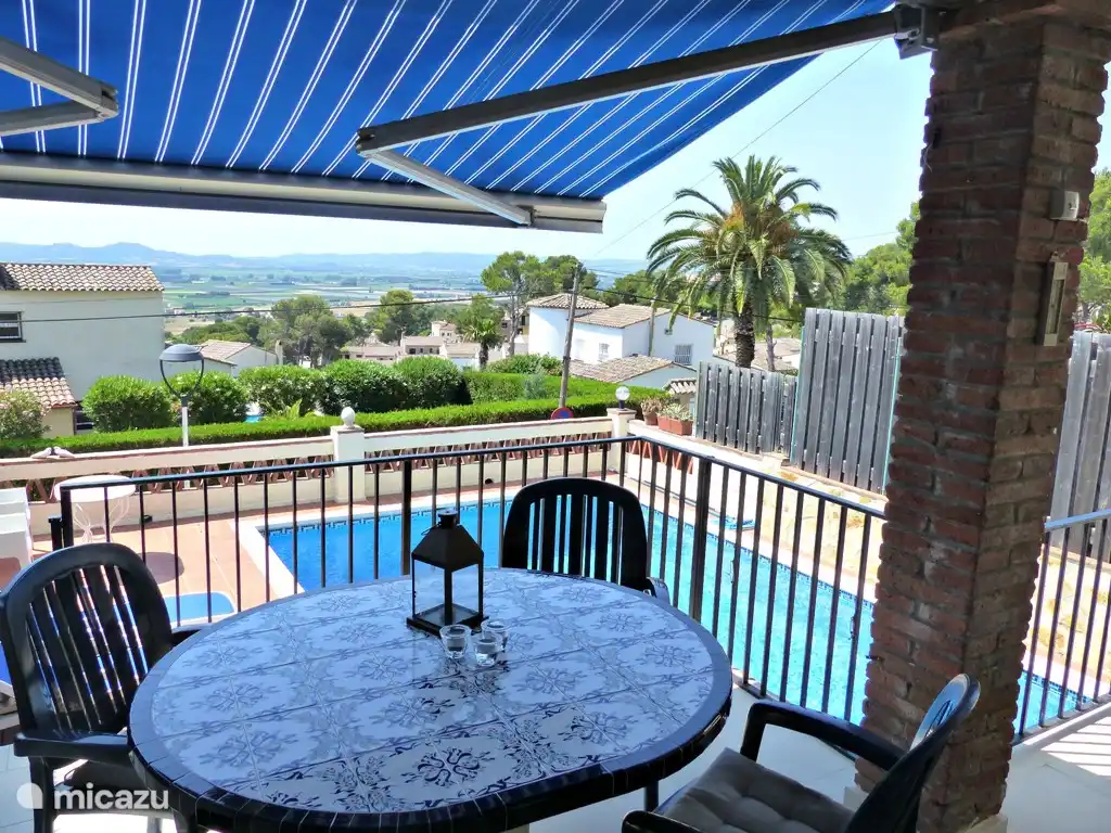 Gartenmöbel auf der überdachten Terrasse mit Blick auf den Pool und Tal / Meer