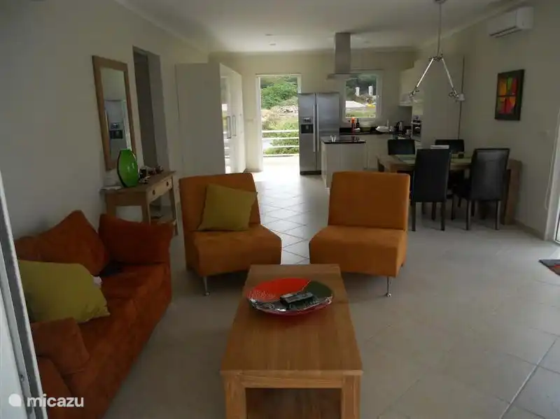 Wohnzimmer an der Front, die eine doppelte Schiebetür zur Terrasse mit Blick auf das Meer hat.