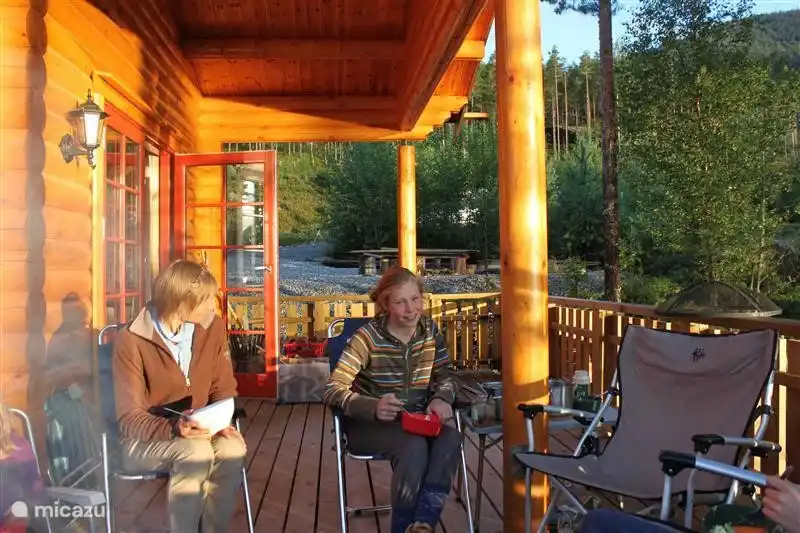 Une partie de la véranda est couverte afin que vous puissiez vous asseoir dehors même par mauvais temps. Il y a maintenant une grande table à manger extérieure en bois avec banc et chaises ici