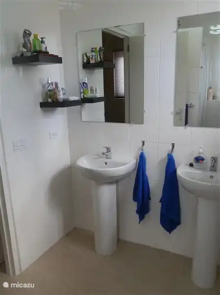 La chambre principale possède sa propre salle de bain moderne avec deux lavabos.