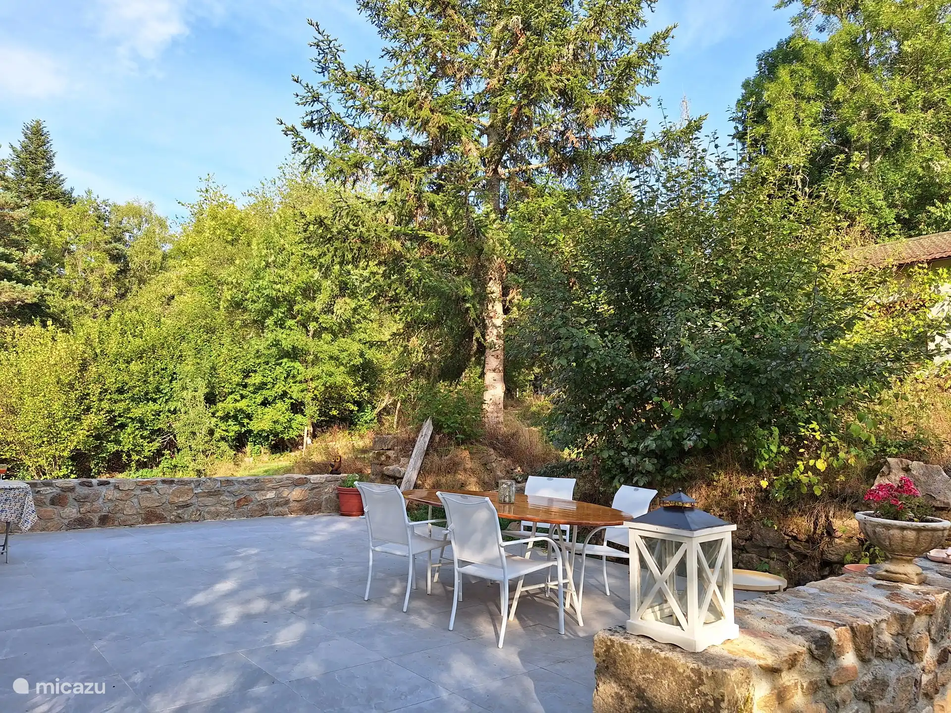 Het terras aan de voorzijde richting het weggetje. U heeft uw eigen parkeerplaats achter de garage.