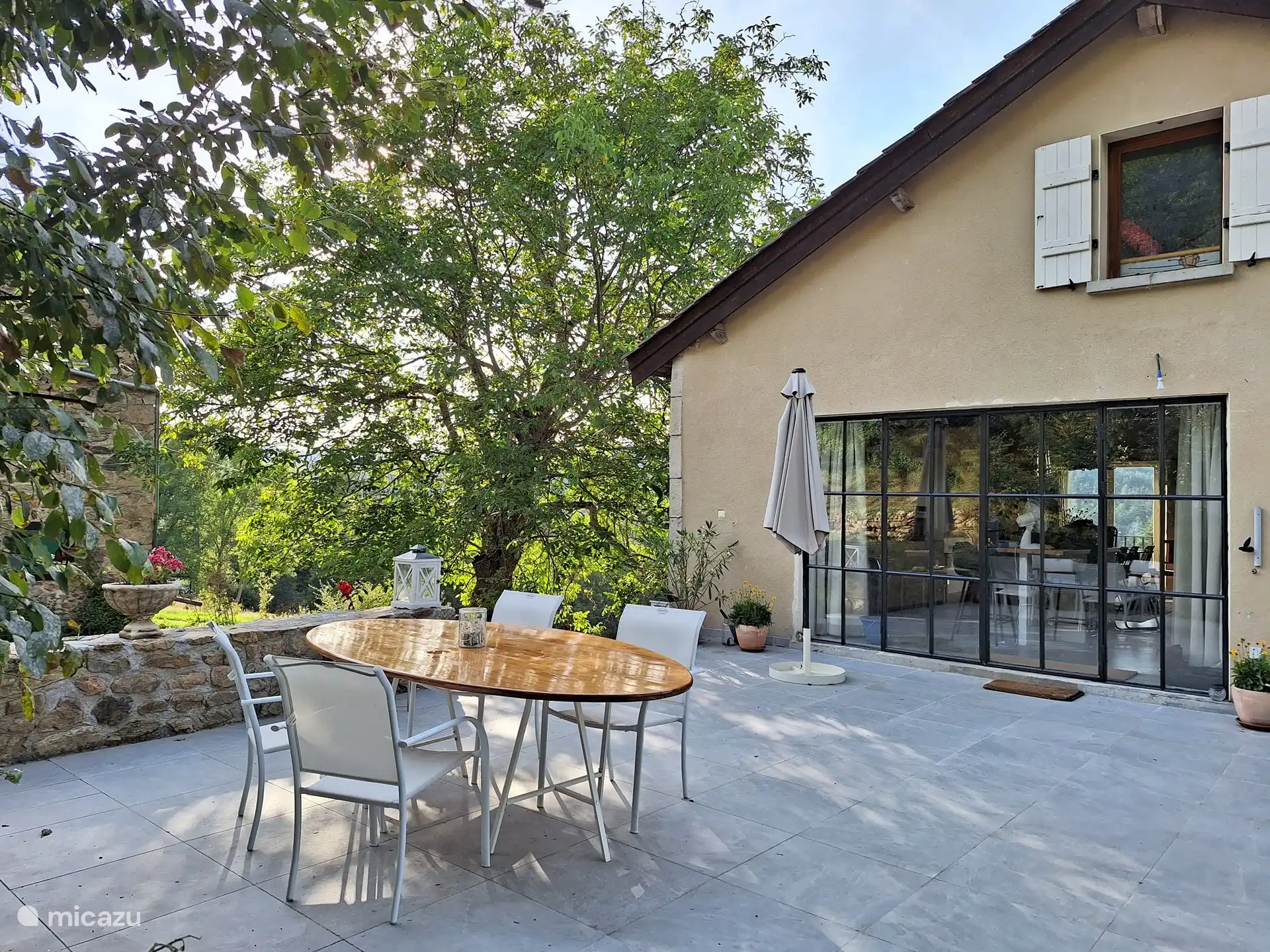 Het grote terras aan de voorzijde van het huis kijkt uit op het weggetje wat er voor langs gaat. Hier komt nauwelijks verkeer.