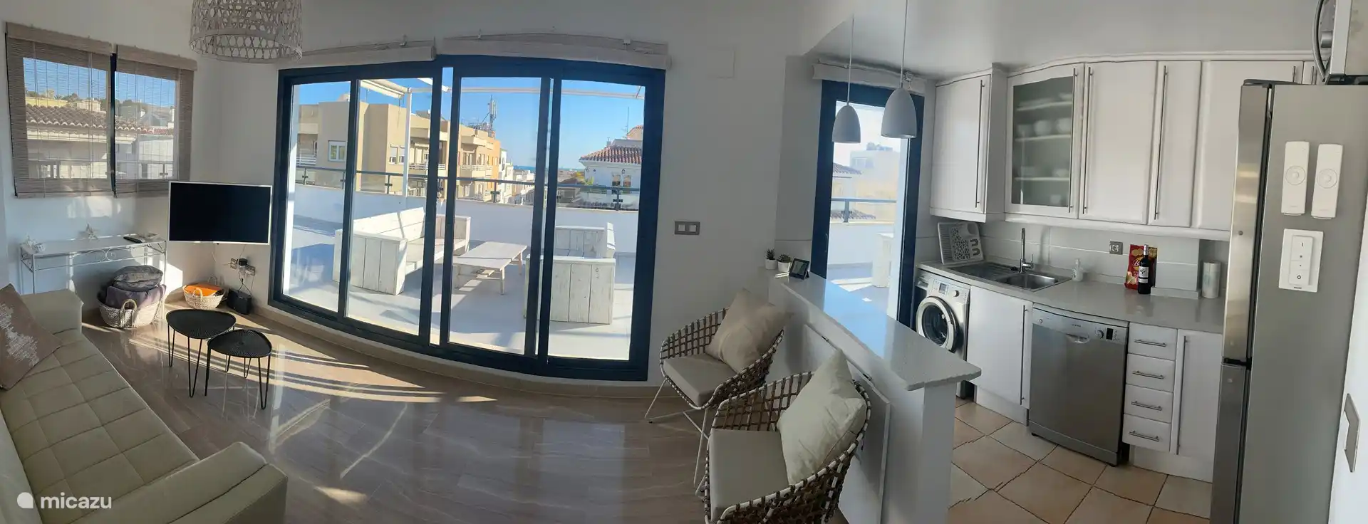 Wohnzimmer mit offener Küche und Schiebetüren zur Terrasse