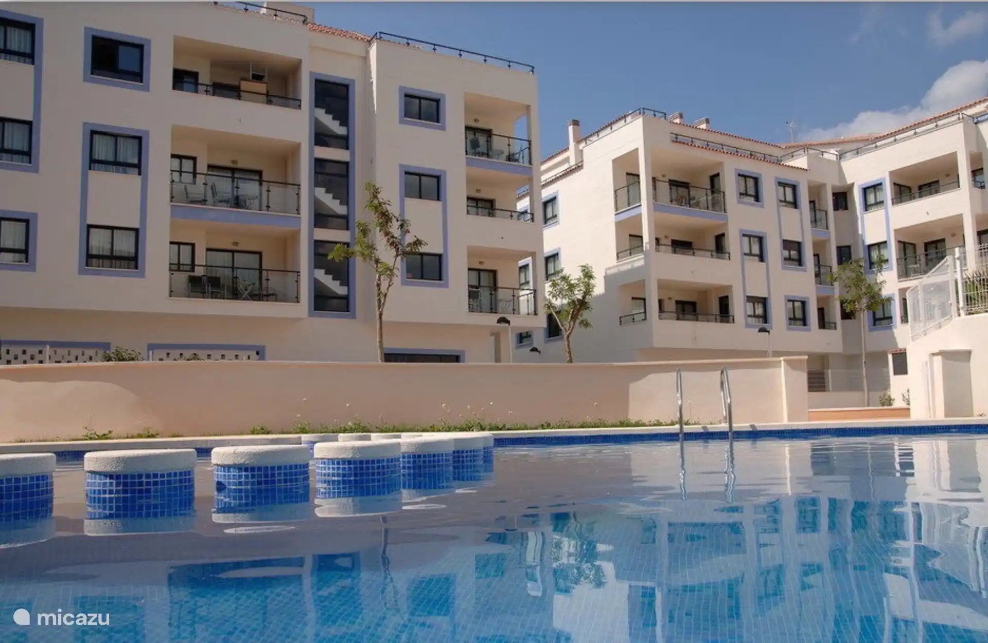 Gemeinschaftsschwimmbad mit abgegrenztem flachem Kinderbereich, Liegewiese und Spielplatz
