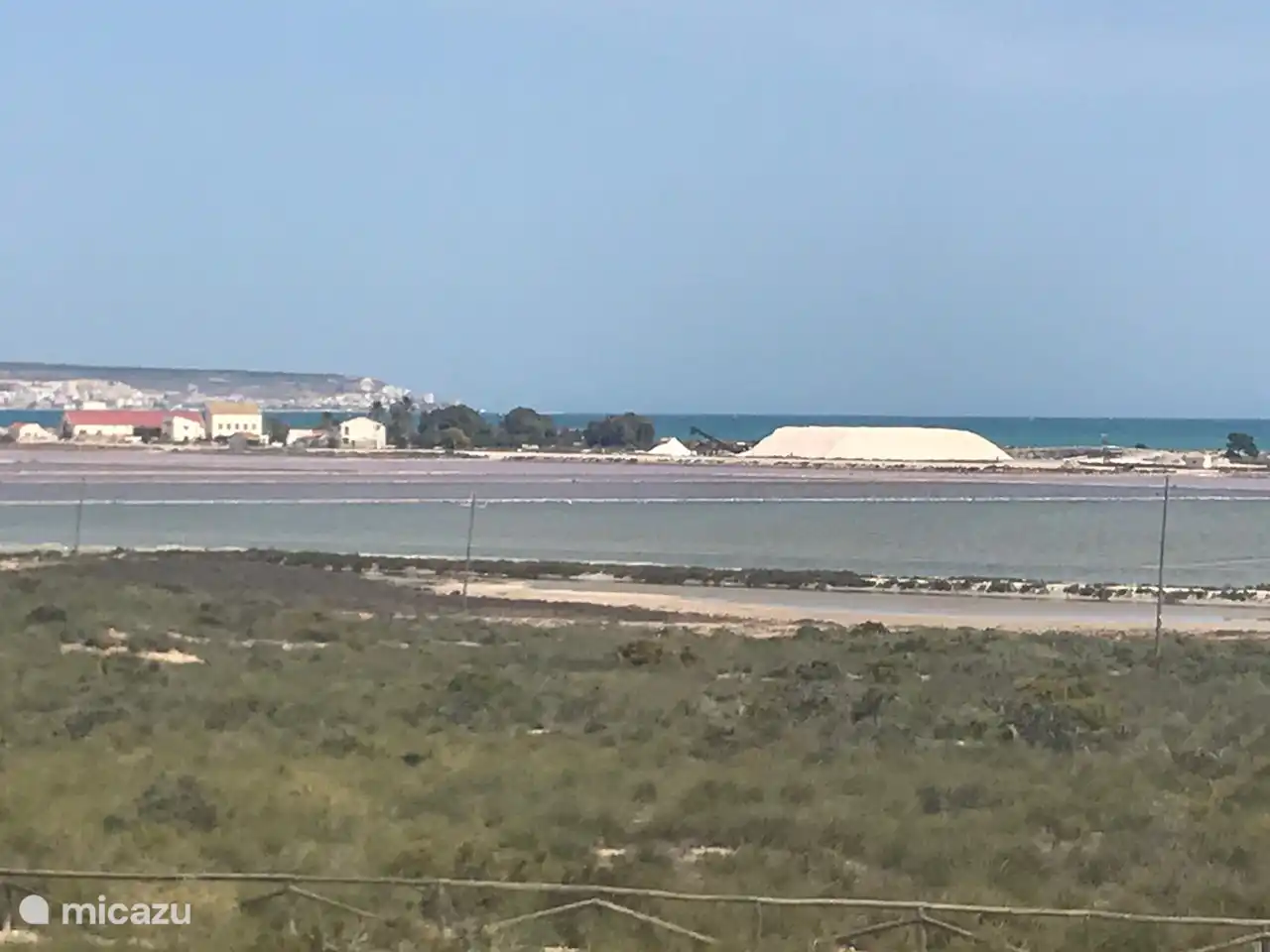 Sobre las salinas de El Pinet se ve una montaña de sal nueva con Santa Pola detrás