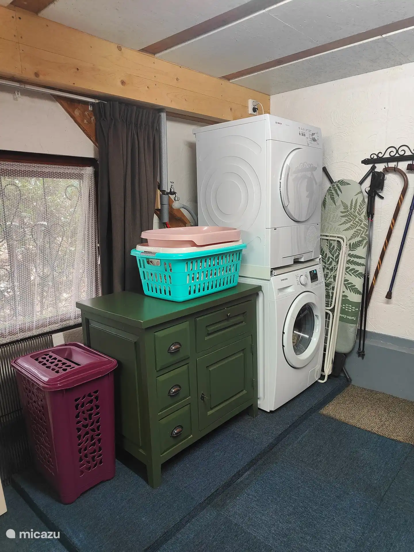 lavadora y secadora, tabla de planchar y plancha en el espacio debajo de la casa