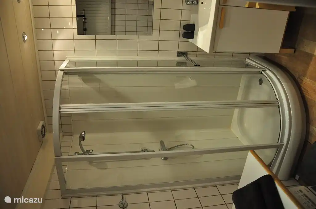 Das Badezimmer mit Dusche, Waschbecken, Badezimmerschränke und eine Waschmaschine, die einen Wickeltisch für Kleinkinder. Das WC ist separat.
