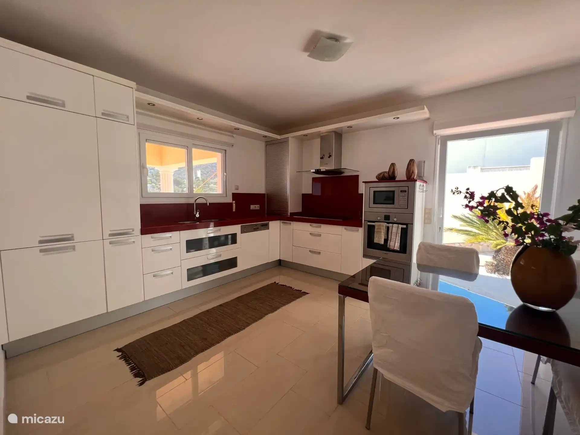 The house has a luxurious built-in kitchen with an induction hob, microwave, oven, coffee and tea machine, fridge and freezer. 