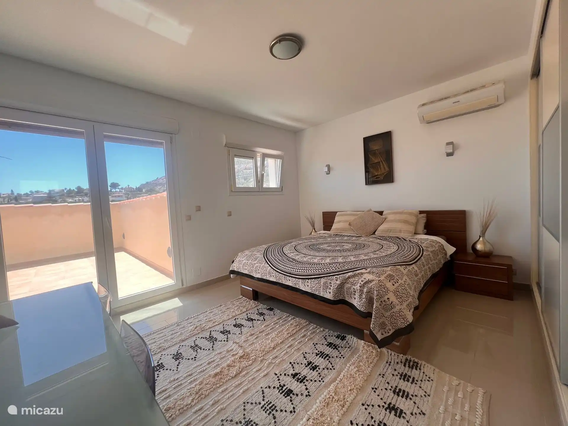 The master bedroom has a door to the outdoor terrace of the upper floor. 