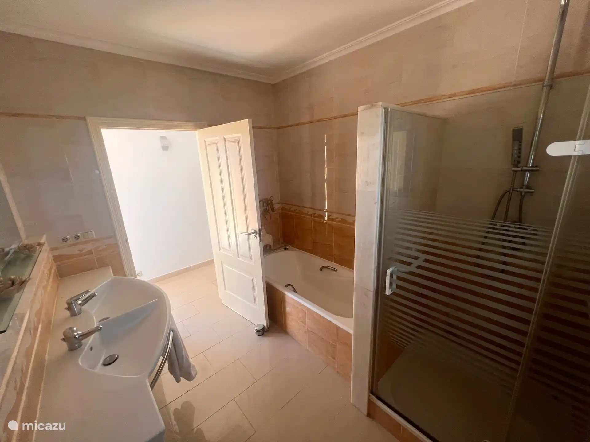 This is the upstairs bathroom. It contains a bathtub, a double sink and a waterfall shower.  