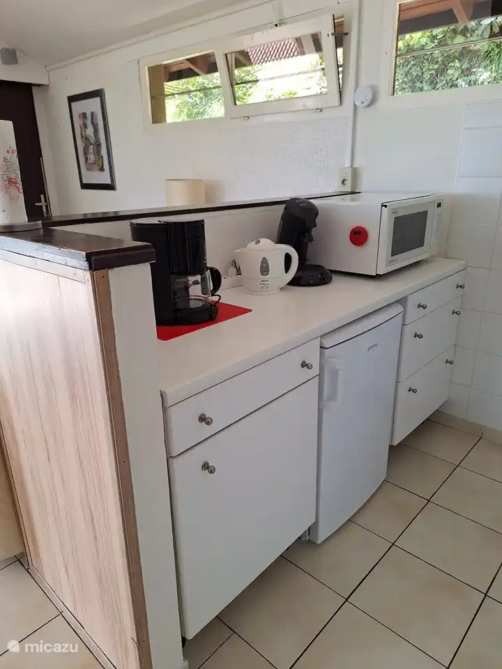 La cocina con todo lo necesario, como una combinación de nevera/congelador, una estufa de gas de cuatro quemadores y un lavavajillas.