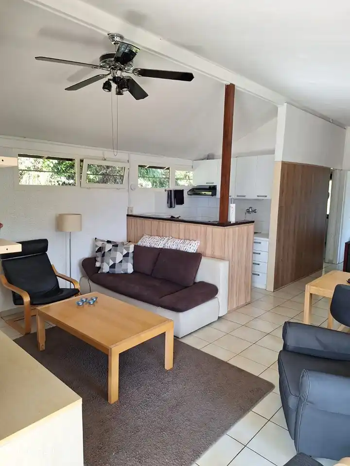 La vista de parte de la sala de estar, la cocina abierta y el pasillo a los dormitorios y baño. El salón tiene un televisor con reproductor de vídeo, reproductor de DVD, libros, películas y juegos de mesa.