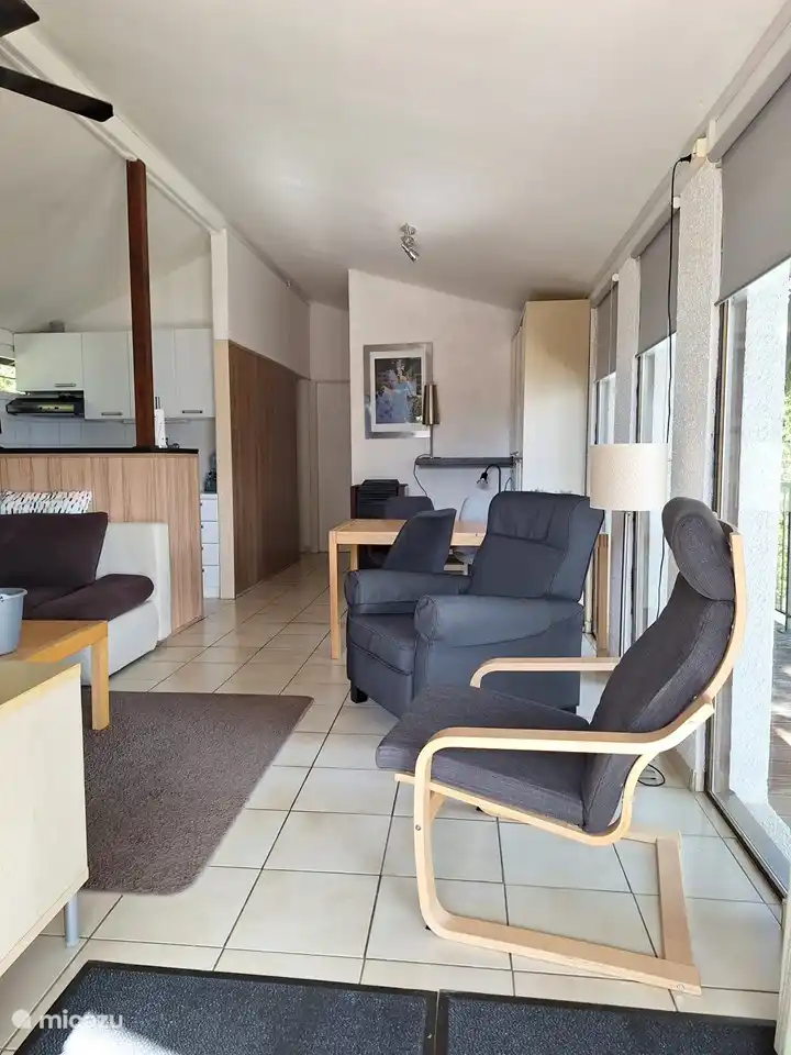 La vista de parte de la sala de estar, la cocina abierta y el pasillo a los dormitorios y baño. El salón tiene un televisor con reproductor de vídeo, reproductor de DVD, libros, películas y juegos de mesa.