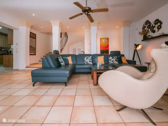 Can Xumeu huren in Spanje, Ibiza, Cala Llonga - villa woonkamer met comfortabele zithoek bij de open haard, flatscreen TV, plafondventilator, en schuifpuien naar het deels overdekte terras