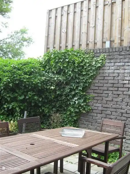 Terrasse mit Gartenmöbeln gezelig Frühstück einfach durch das Fenster der Küche Pass-Through-Durchreiche. Schöner Garten zum Sonnenbaden.