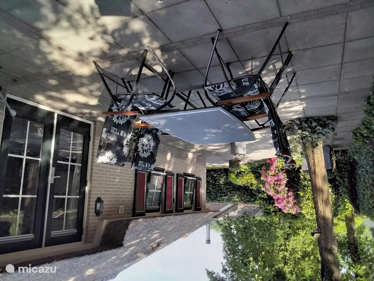 Terrasse avec transats derrière le bungalow à l'ombre sous les chênes